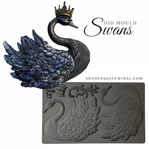 May include: A black swan figurine with a gold crown, iridescent blue and purple feathers, and a gray silicone mold with swan designs. The text "IOD MOULD Swans" is displayed.
