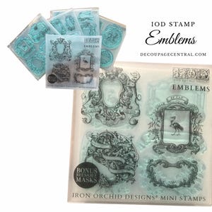 May include: Clear, reusable IOD Emblems mini stamps with various ornate crest and emblem designs. Includes bonus reusable masks. The text "IOD STAMP Emblems" and "DECOUPAGECENTRAL.COM" are visible.