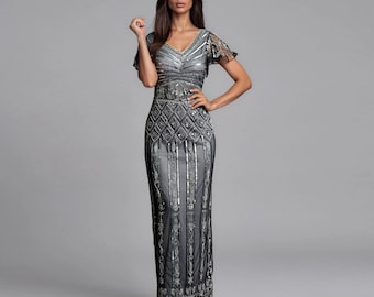 May include: A floor-length grey and black dress featuring short flutter sleeves, a V-neckline, and intricate silver beadwork in geometric diamond and vertical stripe patterns that extend from the bodice down to the hemline of the skirt.