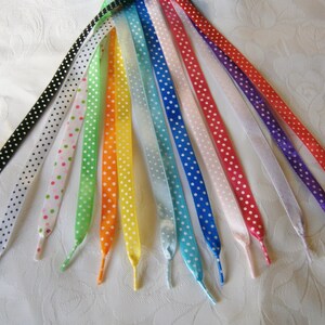 May include: A set of 12 shoelaces with white polka dots on a variety of coloured backgrounds, including black, white, pink, green, orange, yellow, blue, and purple.