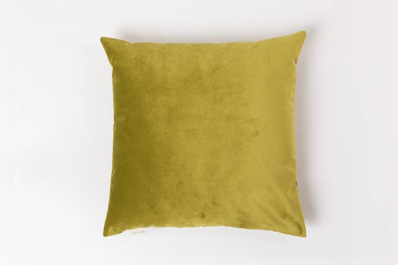 May include: A solid green velvet pillow with a square shape.