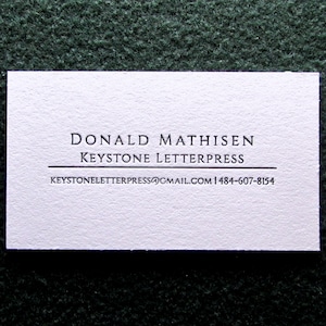 May include: White business card with black text. The text reads "Donald Mathisen, Keystone Letterpress, keystoneletterpress@gmail.com, 1-484-607-8154".