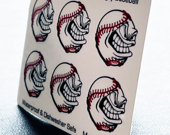 May include: A sheet of five one-inch angry baseball stickers. The stickers are white with red stitching and a black and white angry face. The sheet says "One Inch Angry Baseball" and "Waterproof & Dishwasher Safe" and "Made in USA".