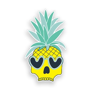 Op de afbeelding: Een sticker met een gele schedel met hartvormige zonnebril, die op een ananas lijkt. De schedel heeft een rasterpatroon en is bedekt met turquoise en lichtgroene bladeren. De sticker heeft een witte rand.