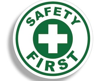 Pode incluir: Um adesivo redondo verde e branco com o texto "SAFETY FIRST" em um círculo ao redor de um sinal de mais branco.
