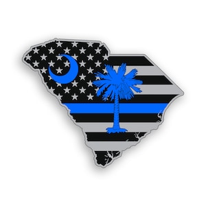 May include: A black and white American flag with a blue line across the middle, superimposed on the outline of the state of South Carolina. The South Carolina state flag is in the upper right corner of the image.