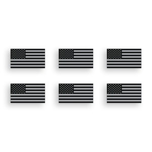 Puede incluir: Seis calcomanías de banderas americanas en blanco y negro. Las banderas son de forma rectangular con fondo blanco y estrellas y rayas negras.