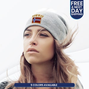 May include: A light gray beanie with the word "NORWAY" embroidered above a Norwegian flag patch. The beanie is worn by a person. The image also includes the text "5 COLORS AVAILABLE".