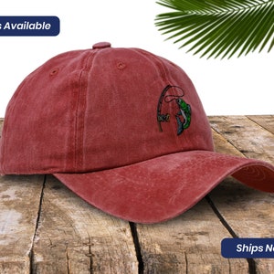 May include: A red baseball cap with an embroidered design of a fish on a fishing line.  "5 Colors Available" is written on the top of the image.