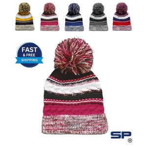 May include: A multi-colored knit beanie with a pom-pom on top. The beanie has stripes of black, white, pink, and red. The pom-pom is a mix of pink, white, and black.