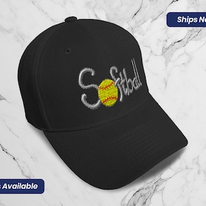 May include: Black baseball cap with a white embroidered softball and the word "Softball" in white.
