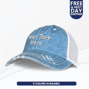 May include: A distressed blue denim baseball cap with a white mesh back. The cap features the embroidered text "Your Text Here" and is available in 5 colors.