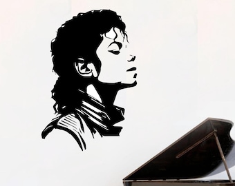 May include: A black vinyl wall decal featuring a stylized silhouette profile of a person with curly hair, positioned above a black grand piano. The graphic design uses bold black lines to define the facial features and hair against a white background.