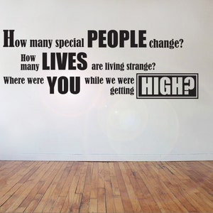 May include: Black and white text on a white wall that reads: "How many special PEOPLE change? How many LIVES are living strange? Where were YOU while we were getting HIGH?"