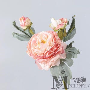 May include: A close-up of a faux peony flower arrangement. The arrangement features a large, open peony in shades of peach and pink, with a yellow center. Two smaller buds and green leaves are also visible. The logo "MINIHAPPYL" is at the bottom.