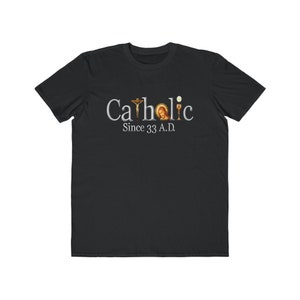 May include: Black t-shirt with a white graphic that says "Catholic Since 33 A.D." The graphic includes a cross, a chalice, and a depiction of Jesus.