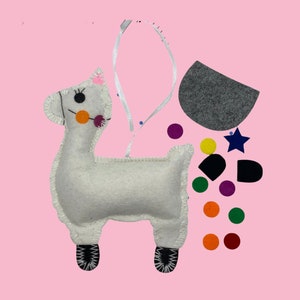 May include: A white felt llama craft kit with felt pieces in various colors, including orange, purple, yellow, green, and black. The kit includes a star, circles, and a rectangle.