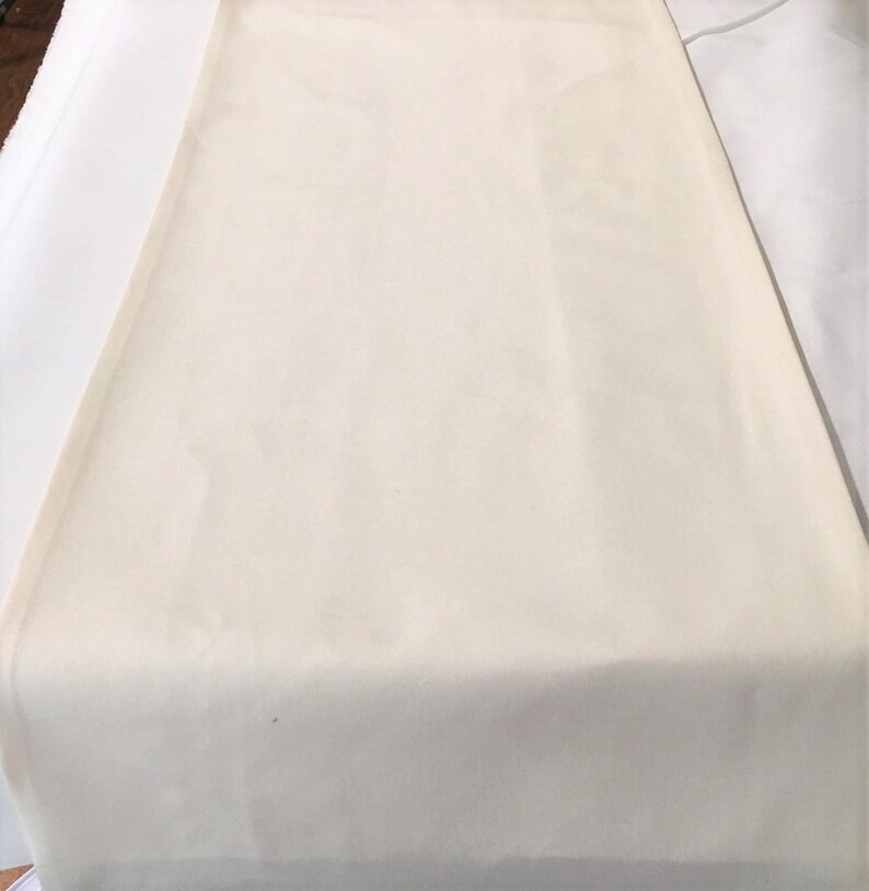 May include: A plain white fabric tablecloth, perfect for a variety of occasions.
