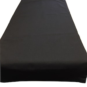 May include: A black table runner made of fabric. The runner is flat and smooth.