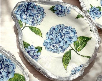 May include: Three white oyster shell dishes with silver edges, each decorated with a blue and green hydrangea flower design.