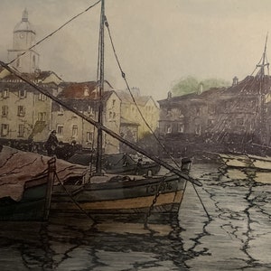 May include: A vintage print of a harbor scene with a sailboat docked in the foreground. The boat is painted in shades of brown, yellow, and green. The harbor is lined with buildings and a church steeple in the background. The water is depicted with a cracked, textured surface.