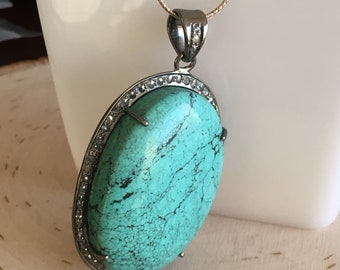 HB5036OVLTRQDIAPNDT- Impresionante colgante turquesa de 50 mm (h) x 36 mm (w) abrazado por diamantes engastados en pavimento. Se vende con una cadena de 20" 925 lista para usar.