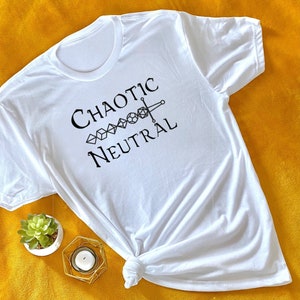 May include: White t-shirt with the text "Chaotic Neutral" and a graphic of a sword and dice.