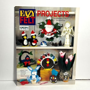 Könnte beinhalten: Das Cover des Buches "Eazy Felt Projects" zeigt verschiedene Filzarbeiten. Dazu gehören Pinguine, ein Weihnachtsmann, ein Engel, ein Truthahn, ein Hase und Blumen. Das Cover enthält auch den Text "15 Friendly Felt Favorites."
