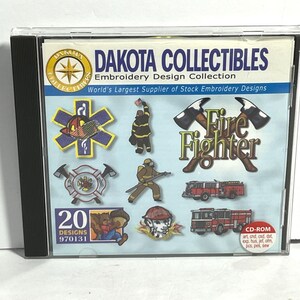 May include: A CD-ROM case featuring the "Dakota Collectibles Embroidery Design Collection." The cover displays various embroidery designs, including a firefighter theme with fire trucks, axes, and a firefighter figure. The case includes 20 designs.