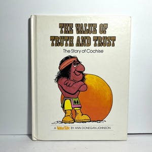 May include: A vintage book titled "The Value of Truth and Trust: The Story of Cochise." The cover shows a cartoon illustration of a Native American figure with a red headband, arms crossed, and a large orange sun. The book is a "ValueTale" by Ann Donegan Johnson.