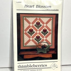 May include: A white ceramic mug with a black handle and the text "But First, Coffee" in a black, handwritten-style font. The mug is on a white surface.