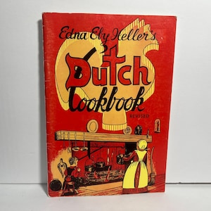 May include: A vintage cookbook titled "Edna Ely Heller's Dutch Cookbook" with a red cover and yellow lettering. The cover features an illustration of a Dutch kitchen scene with a fireplace and figures. "Revised" is printed at the bottom.