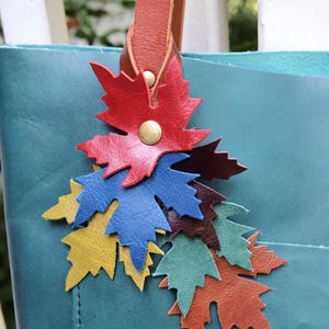 Hermoso bolso otoñal hecho a mano con borlas y dijes de hojas que caen