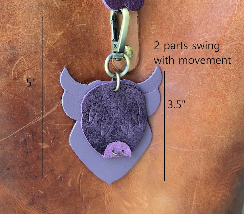 Op de afbeelding: Paarse leren Highland Cow sleutelhanger met een 2-delige zwaaibeweging. De sleutelhanger is 5 inch hoog en 3,5 inch breed.