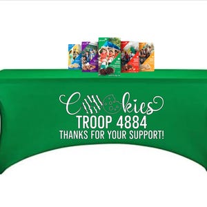 May include: A green table cover with the text "Cookies TROOP 4884 THANKS FOR YOUR SUPPORT!" in white. Several boxes of cookies are displayed on top of the table.