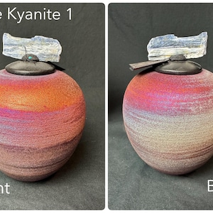 May include: A spherical, handcrafted ceramic vessel with a color gradient from red to purple to tan. It is topped with a black lid and a piece of blue kyanite crystal. The text "Blue Kyanite 1" is visible.