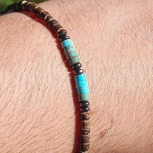 May include: A brown wooden beaded bracelet with turquoise and black beads.