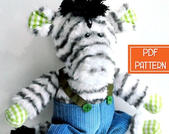 May include: A plush zebra toy wearing blue denim overalls with green gingham trim and green buttons. The zebra has a black and white striped pattern and a black mane. The toy is sitting on a white background. PDF PATTERN.