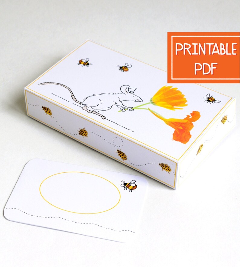 May include: Printable PDF template for a small box with a white mouse carrying two orange flowers. The box is decorated with bees and a dotted line pattern. The template includes a separate card with a bee and a dotted line pattern.