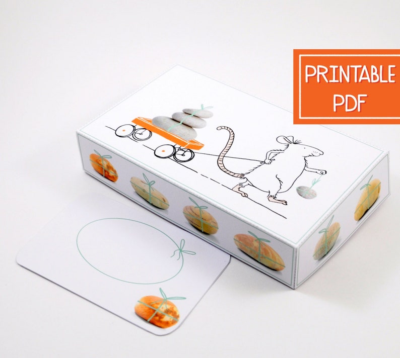 May include: Printable PDF template for a gift box featuring a white mouse pulling a wagon with stacked stones. The box has a white background with a light blue border and a light blue circle for writing a message. The box is decorated with orange and brown gift-wrapped packages.