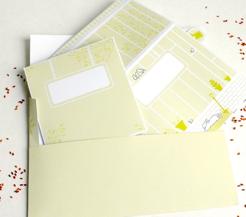 May include: A set of three yellow and white printable cards with a garden theme. The cards have blank spaces for writing and a cute illustration of a bird, a watering can, and a rabbit.
