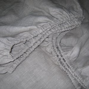 Close-up of the elastic corners of an oatmeal linen fitted sheet