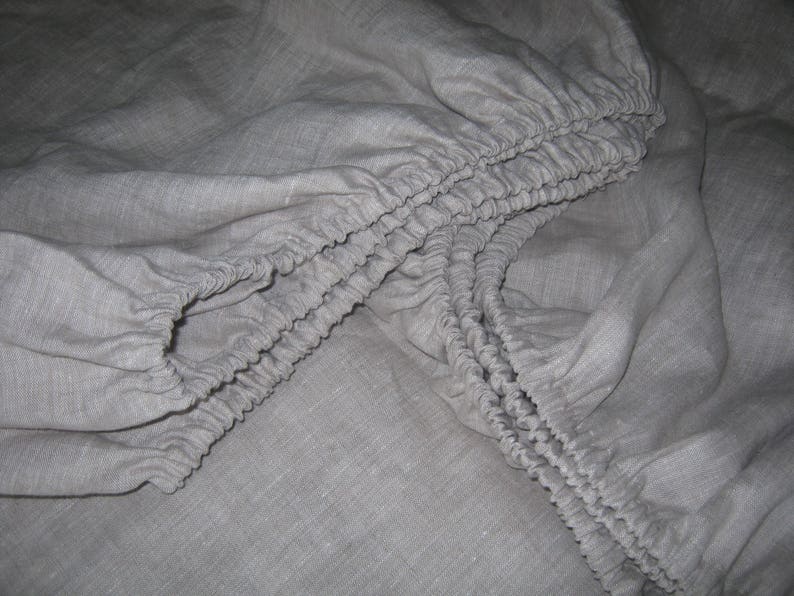 Close-up of the elastic corners of an oatmeal linen fitted sheet