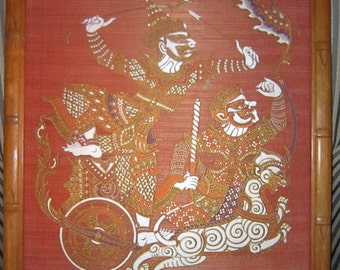 May include: A framed artwork depicting two figures in a chariot pulled by a mythical creature. The figures are painted in gold, white, and red on a red background. The artwork is framed in a natural wood frame.
