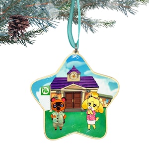 May include: A star-shaped wooden ornament with a colorful image of a school building, a brown dog wearing a Hawaiian shirt, and a yellow dog wearing a pink dress. The school building has a purple roof and a clock tower with the number 2 on the clock face. The ornament has a blue ribbon attached to the top.
