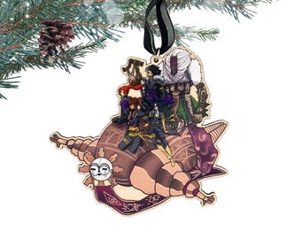 May include: Wooden Christmas ornament featuring a detailed illustration of several figures atop a stylized, brown, snail-like form. The ornament has a black ribbon for hanging and is decorated with a sun-like face and purple accents. The ornament is hanging from a pine branch.