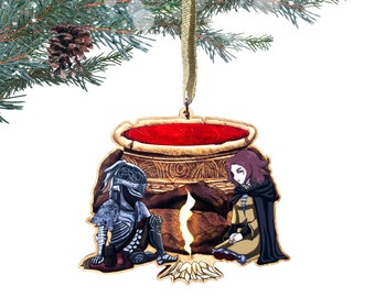 May include: A wooden Christmas ornament featuring a knight in armor and a woman sitting by a campfire. The knight is wearing a silver helmet and armor. The woman has long brown hair and is wearing a brown dress and a black cloak. The campfire is burning brightly and there is a large cauldron in the background.