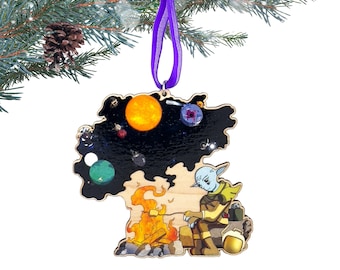May include: Wooden Christmas ornament featuring a space-themed design with a sun, planets, and a cartoon character. The ornament is suspended by a purple ribbon. The background is a Christmas tree branch with a pine cone.