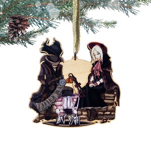 May include: Wooden Christmas ornament featuring two figures, a cloaked figure with a lantern and a woman in a red hooded cloak, standing by a well with two small figures.