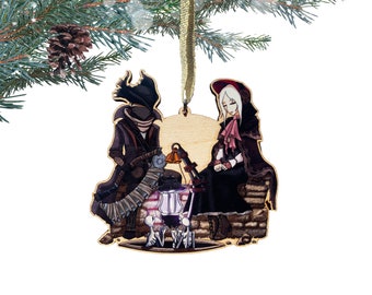 May include: Wooden Christmas ornament featuring two figures, a cloaked figure with a lantern and a woman in a red hooded cloak, standing by a well with two small figures.